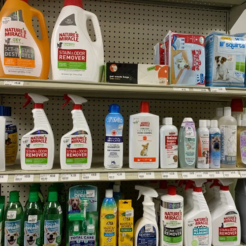 Store aisle stocked with colorful cleaning products, bleach, detergents, and disinfectants on shelves; bright, orderly, practical atmosphere.