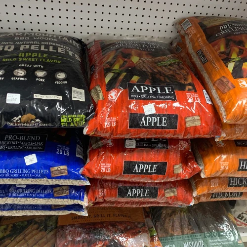 Retail shelves stocked with open boxes of assorted dried pet treats and chews, organized by type in a bright store aisle.