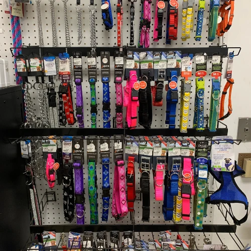 Grocery store shelf stocked with charcoal bags, barbecue wood chips, fire starters, cleaners, and grilling supplies in colorful packaging.
